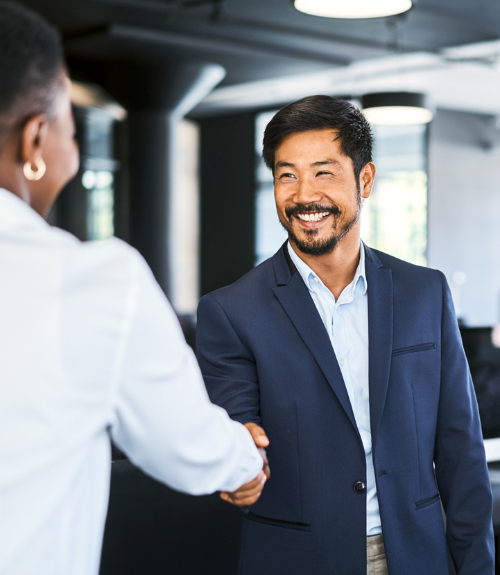 Smiling business man in office shaking clients hand